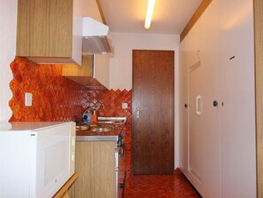 A compact kitchen with a microwave, stove, and sink. - Carmela 1 Appartement/Fewo,   4-Bettwohnung by Interhome (Arosa)
