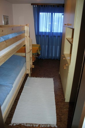 A small, compact room with a bunk bed, a desk, and a chair. - Carmela 1 Appartement/Fewo,   4-Bettwohnung by Interhome (Arosa)