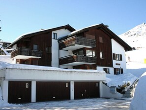 A multi-story building with a wooden facade, balconies, and a garage. - Carmela 1 Appartement/Fewo,   4-Bettwohnung by Interhome (Arosa)