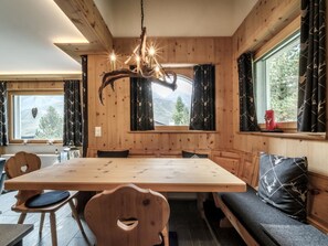 A wooden interior with a dining table, benches, and a chandelier. - Chalet Steinbock by Arosa Holiday Appartement/Fewo, Bad, WC, 3 Schlafräume by Interhome (Arosa)