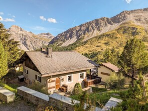 A mountain lodge with a sloped roof, a wooden deck, and a stone wall. - Chalet Steinbock by Arosa Holiday Appartement/Fewo, Bad, WC, 3 Schlafräume by Interhome (Arosa)