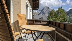 A wooden deck with a round table and chairs, overlooking a mountainous landscape. - Chalet Steinbock by Arosa Holiday Appartement/Fewo, Bad, WC, 3 Schlafräume by Interhome (Arosa)