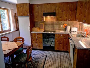A kitchen with wooden cabinets, a tiled backsplash, and a window. - I dr Rehwiesa C21 Appartement/Fewo, Bad, WC, 4-Bettwohnung 4-Bettwohnung by Interhome (Arosa)