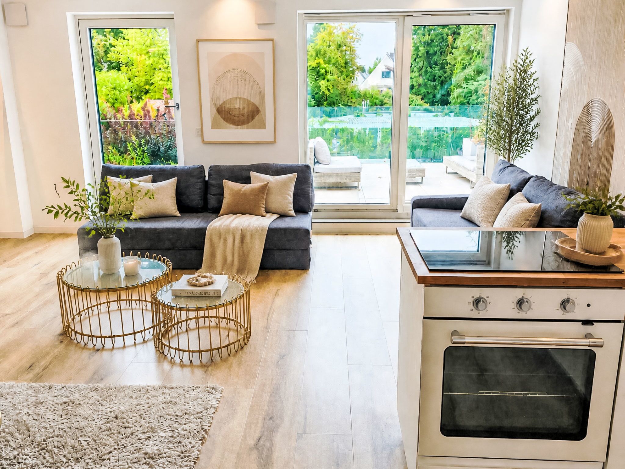 Ein modernes Wohnzimmer mit einer Couch, einem Couchtisch und einer Küchenzeile mit Backofen.