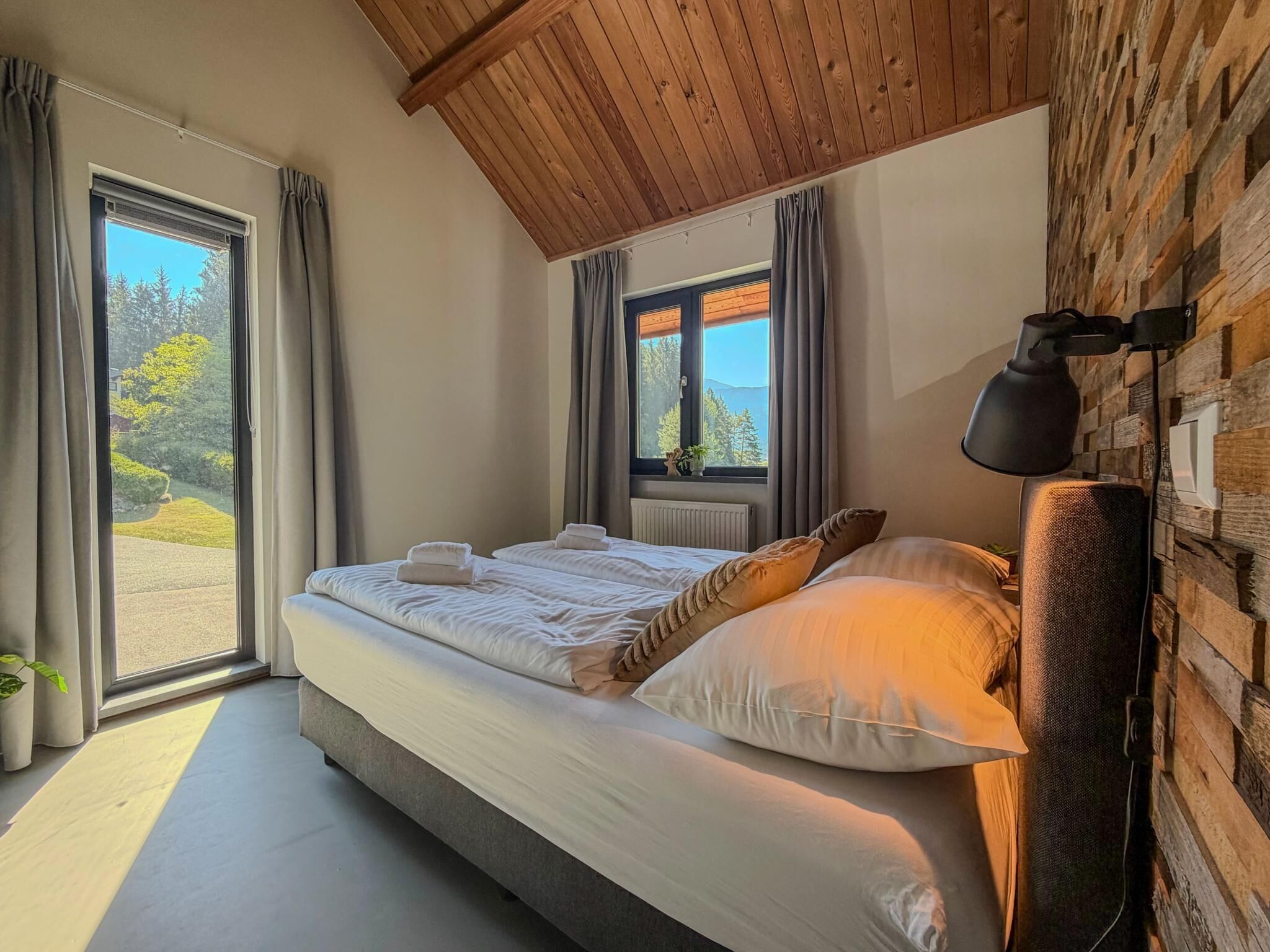 A bedroom with a bed, a window, a radiator, and a lamp.
