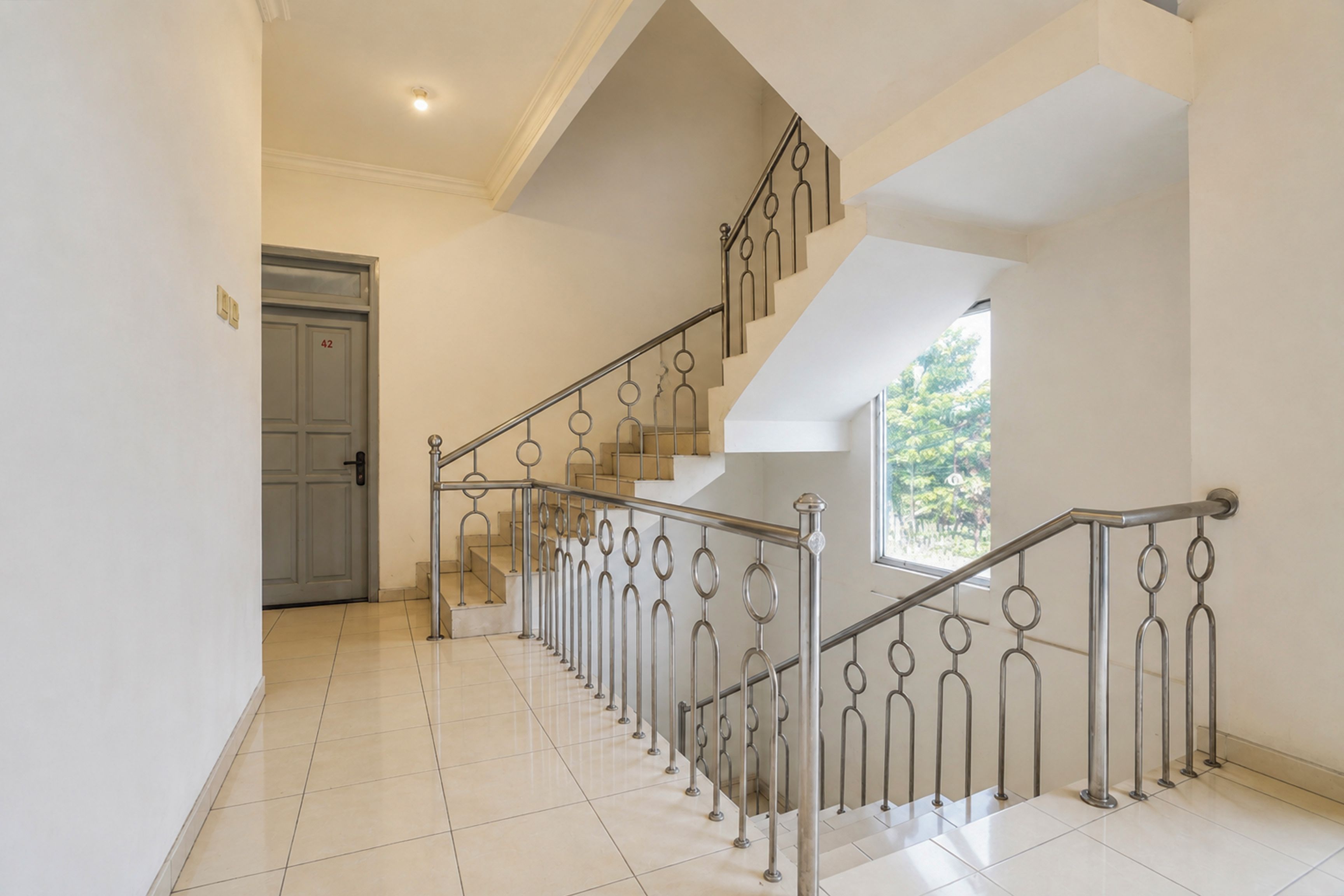 A staircase with metal railings and a door labeled '42' leading to an upper floor.