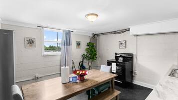 Enjoy a cozy dining space right in the heart of the kitchen in Unit B, featuring a farmhouse table that makes every meal feel inviting.