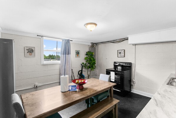 Enjoy a cozy dining space right in the heart of the kitchen in Unit B, featuring a farmhouse table that makes every meal feel inviting.