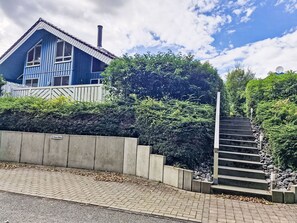 A blue house with a chimney, a white fence, and a staircase leading up to it. - Vacation home Nina by Interhome (Extertal)