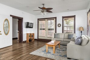 A living room with a ceiling fan, a sofa, a coffee table, and a bookshelf. - The Jefferson House |Private Parking |Group Stays (Birmingham)