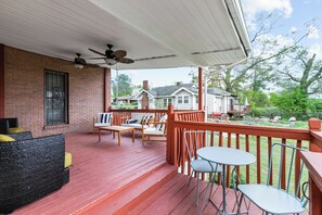 A covered porch with outdoor furniture, a brick wall, and a view of neighboring houses. - The Jefferson House |Private Parking |Group Stays (Birmingham)