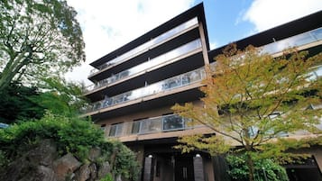 Un immeuble à plusieurs étages doté d’une architecture moderne, avec des balcons et un espace d’entrée aménagé.