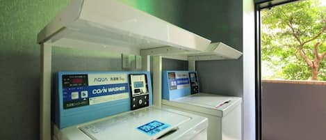 A coin-operated washer with a digital display and a coin slot.