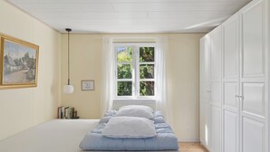 A bedroom with a bed, a window, a painting, and a bookshelf. - Charming holiday home in beautiful Asserbo (Liseleje)