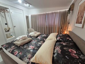 A bedroom with a bed, a wardrobe, a bedside table, and a window with curtains. - House Tilia Mellis by Interhome (Lužan Biškupečki)