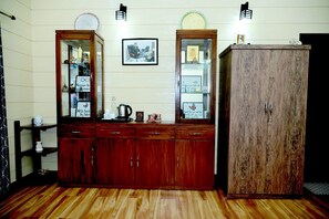 A wooden cabinet with glass doors, a framed picture, and a small shelf with items.