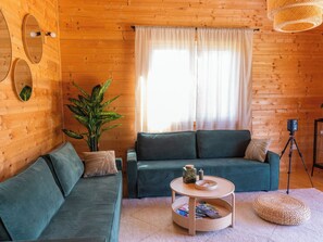 A cozy room with a green sofa, a small round table, and a potted plant. - House Dobra vila by Interhome (Zadobarje)