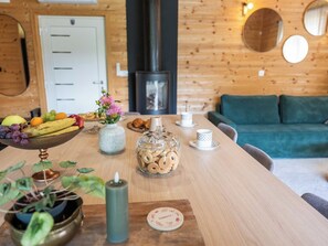 A wooden dining table with fruits, a vase, a candle, and a cookie jar. - House Dobra vila by Interhome (Zadobarje)