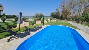 Una piscina con lettini e vista su un lago.