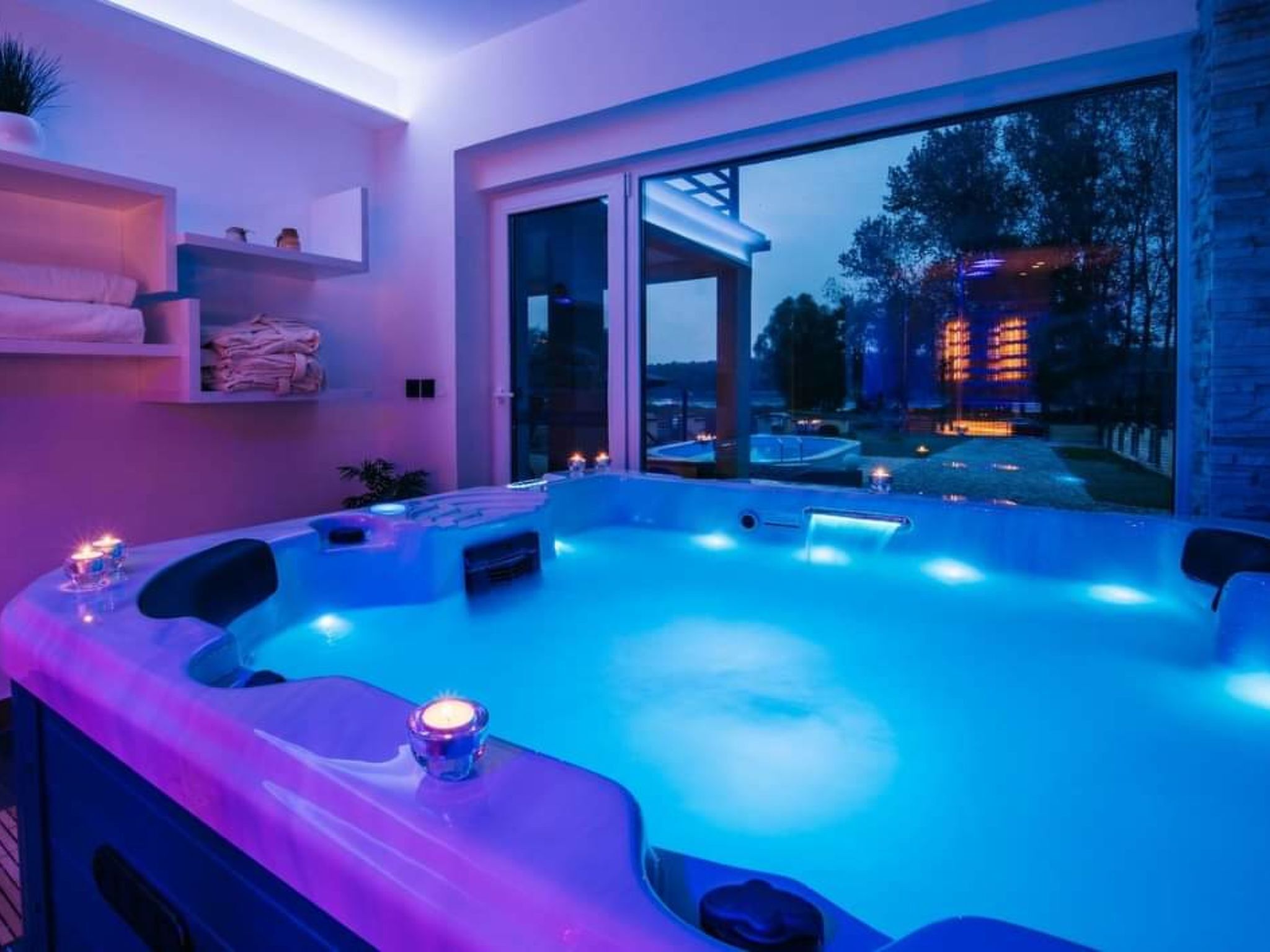 Un bain à remous avec vue sur un bâtiment et des arbres, au crépuscule.