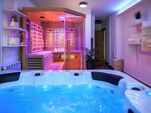 A modern spa area with a hot tub, wooden shelves, and a relaxation room with a sign reading 'HOME DELUXE'.