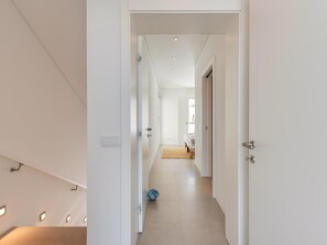 A modern hallway with a wooden floor, white walls, and a door leading to another room. - Luxury Villa, Sea View and Pool, Central Lagos (Lagos)