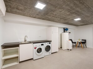A compact kitchen with a washing machine, a sink, and a compact refrigerator. - Luxury Villa, Sea View and Pool, Central Lagos (Lagos)