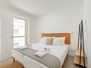 A hotel room with a large bed, a wooden headboard, a standing lamp, and a view of the outside. - Luxury Villa, Sea View and Pool, Central Lagos (Lagos)