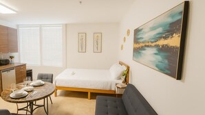 Un dormitorio moderno con cama, mesita de noche y un ventanal amplio.