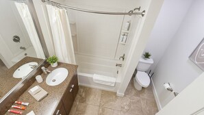 Un baño con dos lavamanos, una bañera y un inodoro.