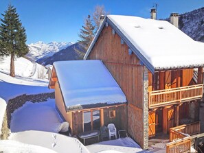 A wooden cabin with a balcony, a covered porch, and a view of snow-covered mountains. - Vista Mont Blanc by Interhome (Celliers)