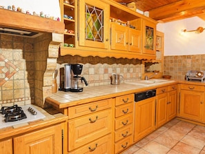 A kitchen with wooden cabinets, a coffee maker, and a dishwasher. - Chalet Villaroger by Interhome (Villaroger)