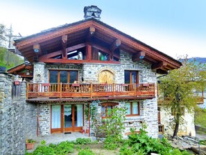 A two-story stone house with a wooden balcony and a wooden door. - Chalet Villaroger by Interhome (Villaroger)