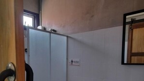 Une petite salle de bain comprenant des toilettes, un lavabo et un espace douche.