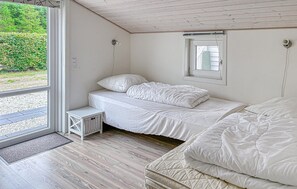 A bedroom with a bed, a small bedside table, a window, and a door leading to an outdoor area. - Stunning home in Hemmet with WiFi (Hemmet)