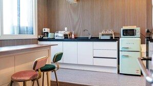 A kitchen with a window, a sink, a microwave, and a refrigerator.