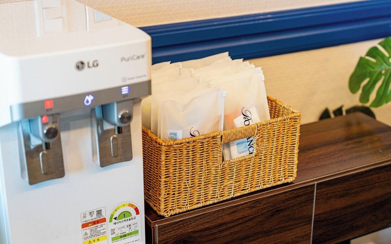 A water dispenser with a basket of tissues on a wooden counter.