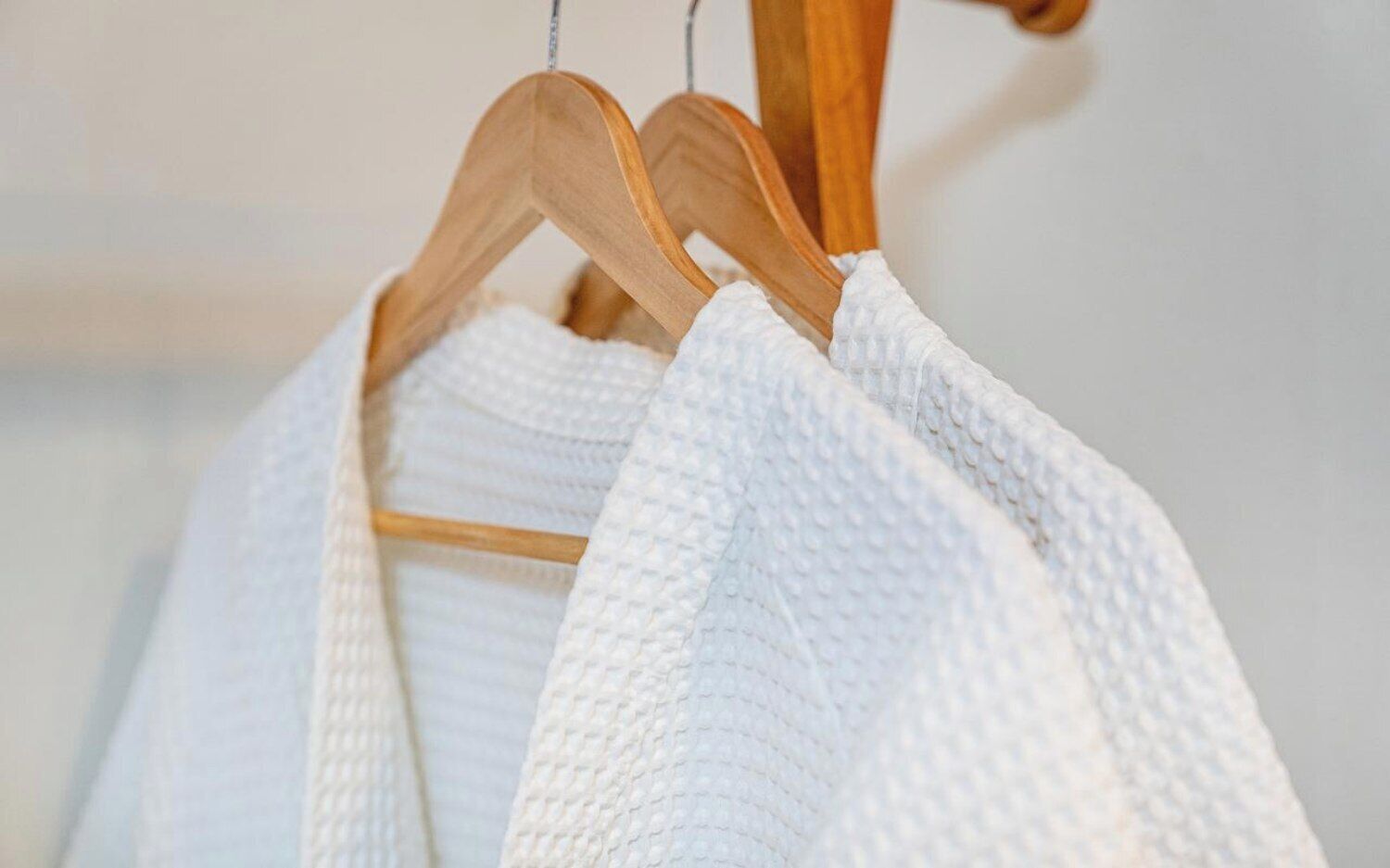 A white textured garment hanging on a wooden hanger.