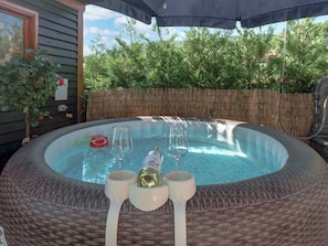 A hot tub with two glasses and a bottle, surrounded by a wicker table and chairs. - House Rukova Hiža by Interhome (Donja Stubica)