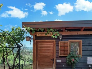 A wooden building with a large wooden door, a small window with shutters, and a hanging sign with text. - House Rukova Hiža by Interhome (Donja Stubica)