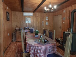 A wooden interior with a dining table set for four, a chandelier, and a fireplace. - House Rukova Hiža by Interhome (Donja Stubica)