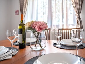 A dining table set with wine glasses, plates, and a bottle of wine. - House Blackberry Hill by Interhome (Kupinovac)