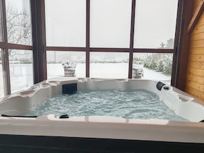 A hot tub with a view of a snowy landscape through large windows. - House Blackberry Hill by Interhome (Kupinovac)