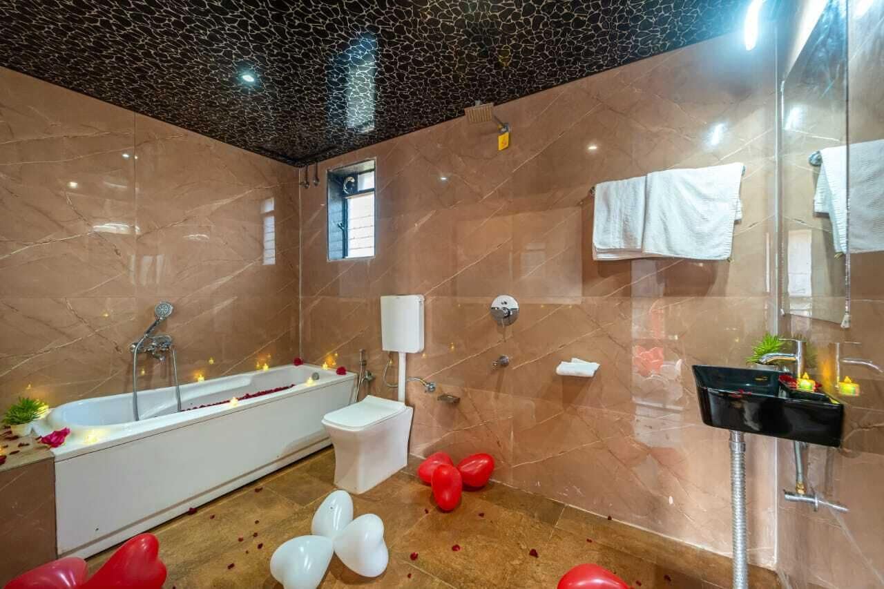 A modern bathroom with a bathtub, a toilet, and a shower area.