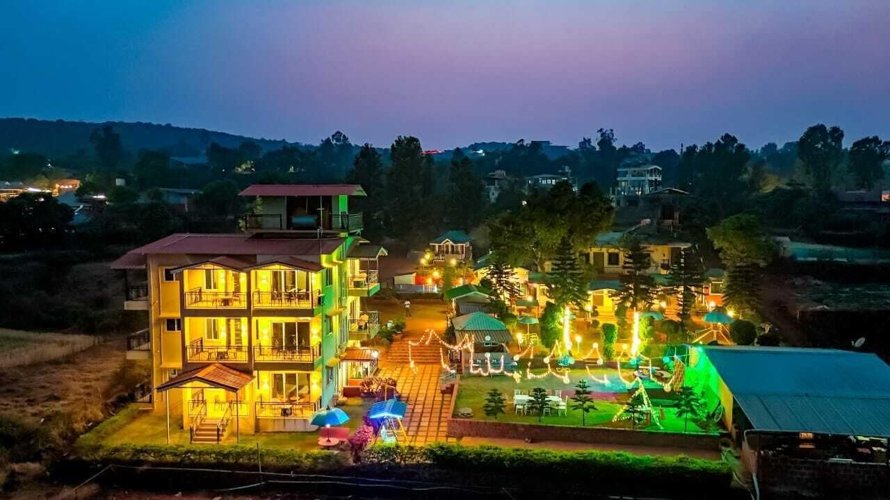 Un edificio de varios pisos con balcones y un espacio exterior bien iluminado.