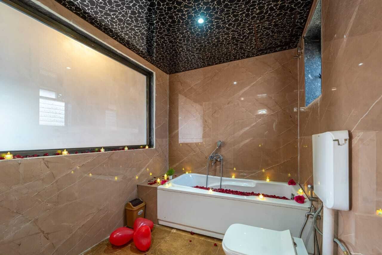A bathroom with a bathtub, a toilet, and a shower area.