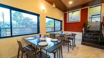 A dining area with a table set for four, chairs, and a staircase leading to an upper level.
