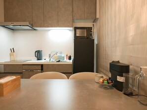 A modern kitchen with a microwave, refrigerator, and a coffee maker.