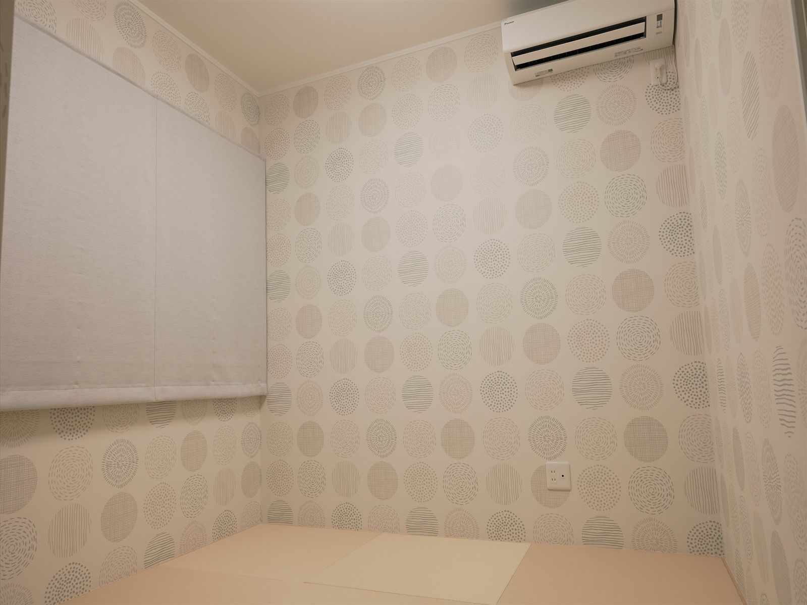A bathroom with patterned wallpaper, a towel rack, and a wall-mounted air conditioner.