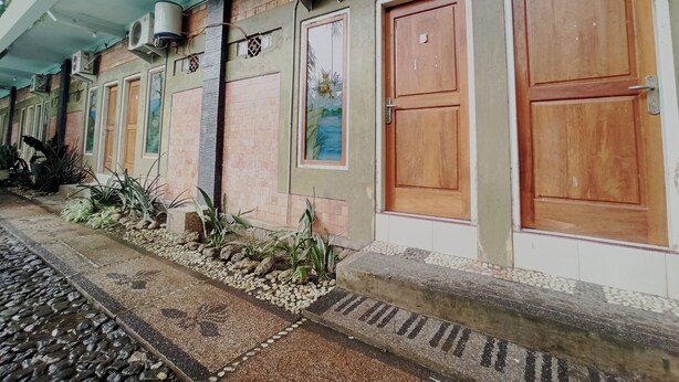 Un edificio con varias puertas, unidades de aire acondicionado y una entrada con baldosas.